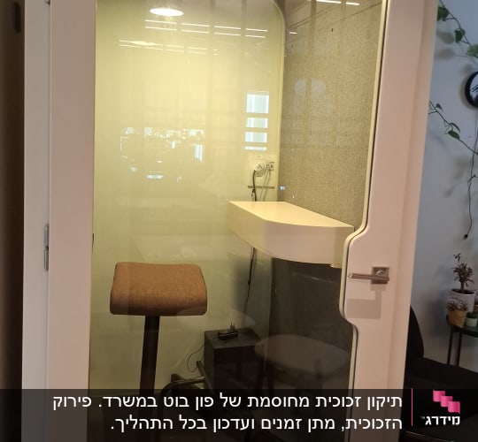 תא זכוכית עם כיסא ושולחן בפנים